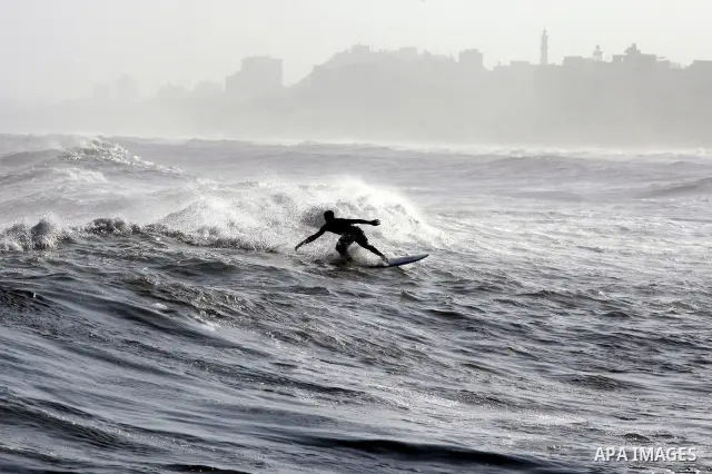 A Palestinian surfer rides a wave during a practise session in Gaza City on July 17, 2011 . Photo by Mahmud Nassar