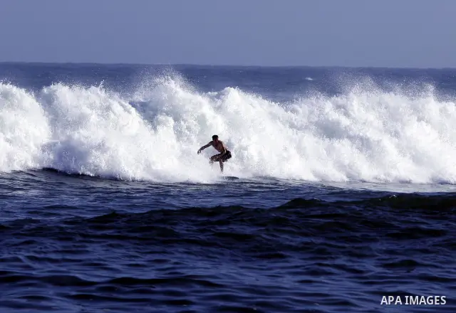 A Palestinian surfer rides a wave during a practise session in Gaza City on July 17, 2011 . Photo by Mahmud Nassar