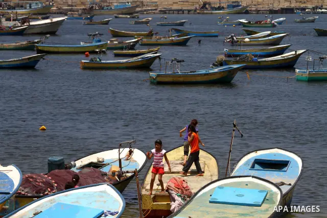 Palestinian children enjoy playing on a boat at the Gaza seaport July 19, 2011. The Israeli navy on Tuesday boarded a French yacht carrying pro-Palestinian activists intending to sail to the blockaded Gaza Strip and forc...