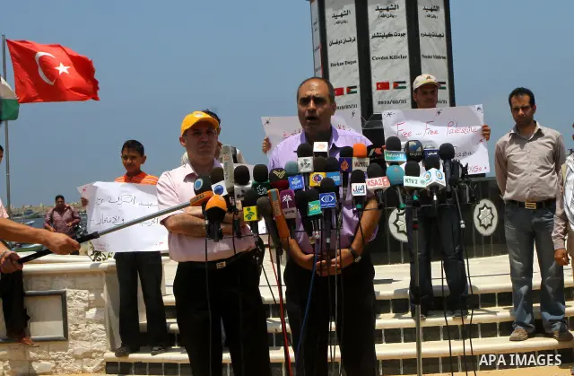 A Palestinian man delivers speech at a protest at the Gaza seaport July 19, 2011. The Israeli navy on Tuesday boarded a French yacht carrying pro-Palestinian activists intending to sail to the blockaded Gaza Strip and fo...