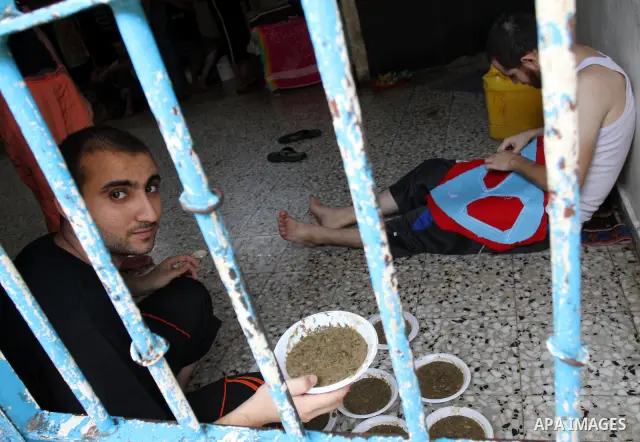 Palestinian inmates receive donated food from an Islamic charity at their cell in Gaza city on July 19,2011 . Photo by Mohammed Asad