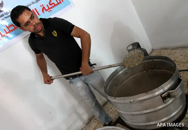 Palestinians receive donated food from an Islamic charity at a Palestinian hospice in Gaza city on July 19,2011. Photo by Mohammed Asad