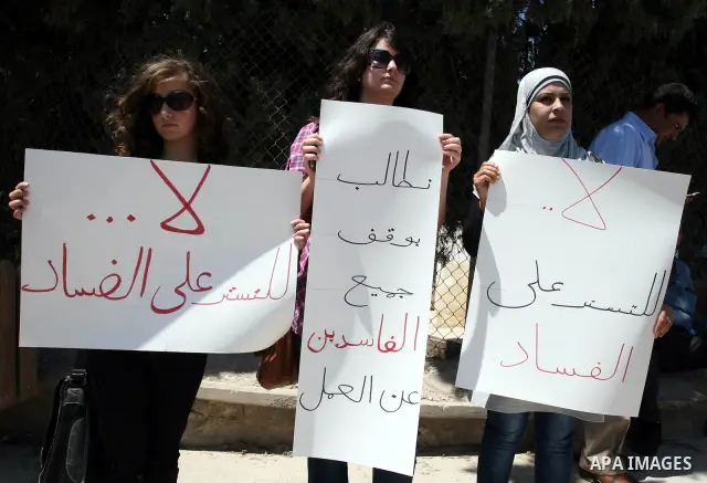 Palestinians take part in a protest outside the ministers council headquarters in the West Bank city of Ramallah on July 19, 2011, calling for the trial of ministers and officials accused of financial and administrative...