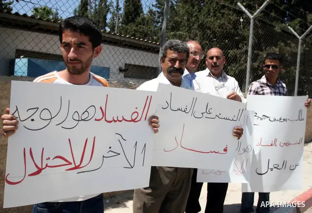 Palestinians take part in a protest outside the ministers council headquarters in the West Bank city of Ramallah on July 19, 2011, calling for the trial of ministers and officials accused of financial and administrative...