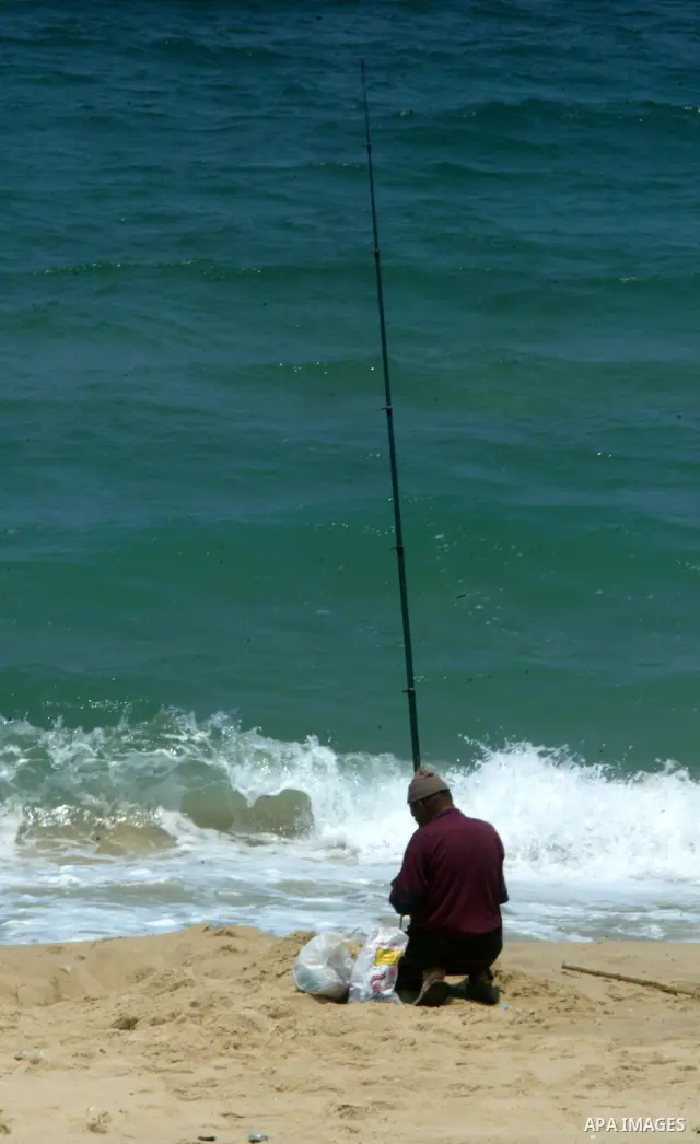 A Palestinian man fishes at Rafah beach in the southern Gaza Strip on July 19, 2011. Israeli naval commandos on Tuesday seized control of a French ship attempting to break Israel's blockade of the Gaza Strip, reporting n...