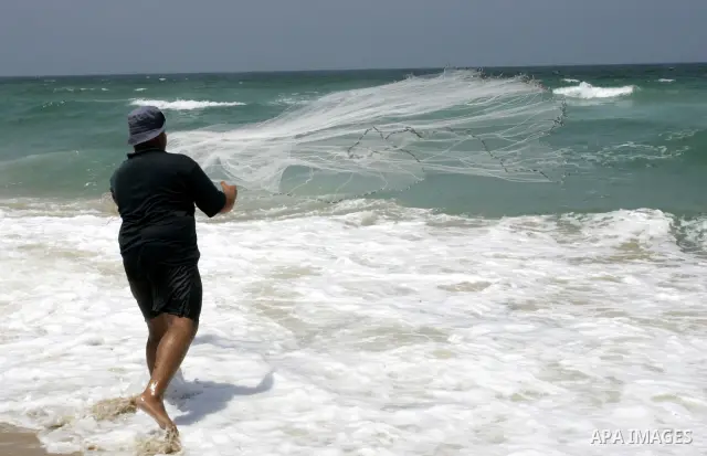 A Palestinian man fishes at Rafah beach in the southern Gaza Strip on July 19, 2011. Israeli naval commandos on Tuesday seized control of a French ship attempting to break Israel's blockade of the Gaza Strip, reporting n...