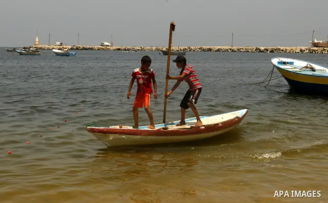 Palestinian children ride a boat at Gaza city port on July 19, 2011. Israeli naval commandos on Tuesday seized control of a French ship attempting to break Israel's blockade of the Gaza Strip, reporting no resistance dur...