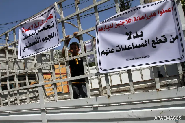 A Palestinian boy holds banner during closing the gates of the UNRWA headquarters in Gaza against the UNRWA decision to change its name in Gaza city on July 20, 2011. .Photo by Mohammed Asad