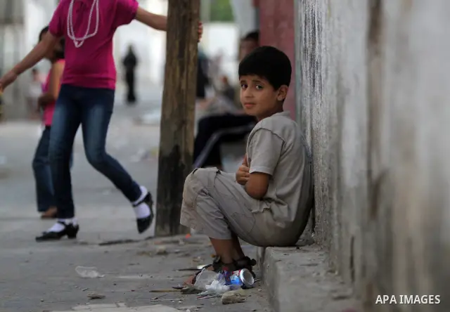 A Palestinian boy sits in front of her house in Jabaliya refugee camp in the northern area of the Gaza Strip on July 21, 2011. The UN Relief and Works Agency (UNRWA) will reduce some of its services for Palestinian refug...