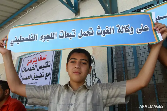 A Palestinian boy holds banner during a protest infront of the UNRWA headquarters against the UNRWA decision to change its name and Reduce aid in Gaza city on July 21, 2011. Photo by Ashraf Amra