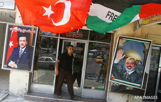 A Palestinian vendor displays pictures of Turkish Prime Minister Recep Tayyip Erdogan and of Hamas leader, Ismail Haniyeh, outside his shop in Gaza City on July 21, 2011 following Erdogan's statement that he was consider...