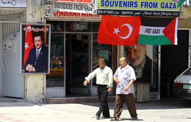 A Palestinian vendor displays pictures of Turkish Prime Minister Recep Tayyip Erdogan and late Palestinian leader Yasser Arafat, outside his shop in Gaza City on July 21, 2011 following Erdogan's statement that he was co...