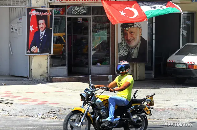 A Palestinian vendor displays pictures of Turkish Prime Minister Recep Tayyip Erdogan and late Palestinian leader Yasser Arafat, outside his shop in Gaza City on July 21, 2011 following Erdogan's statement that he was co...