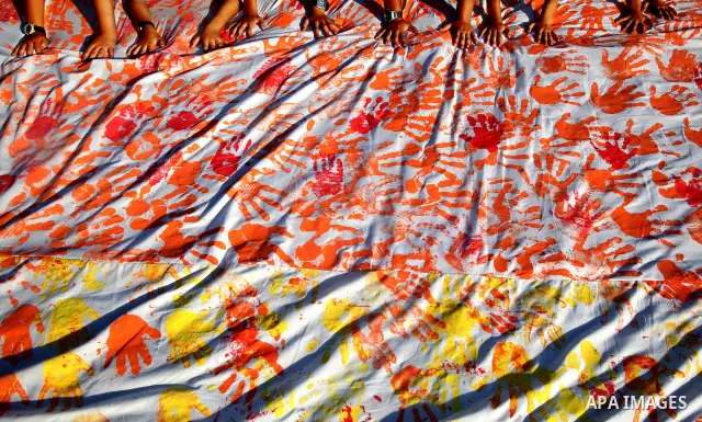 Palestinian children attend an event organised by the the United Nations Relief and Works Agency (UNRWA) in which they attempt to break the Guinness world record for the largest hand-print paint in Khan Yunis, southern G...