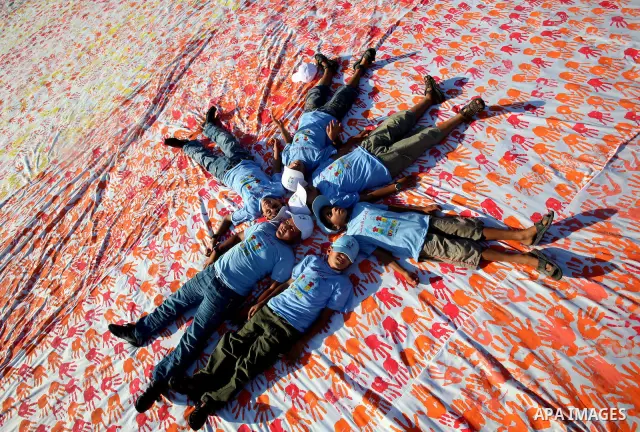 Palestinian children attend an event organised by the the United Nations Relief and Works Agency (UNRWA) in which they attempt to break the Guinness world record for the largest hand-print paint in Khan Yunis, southern G...