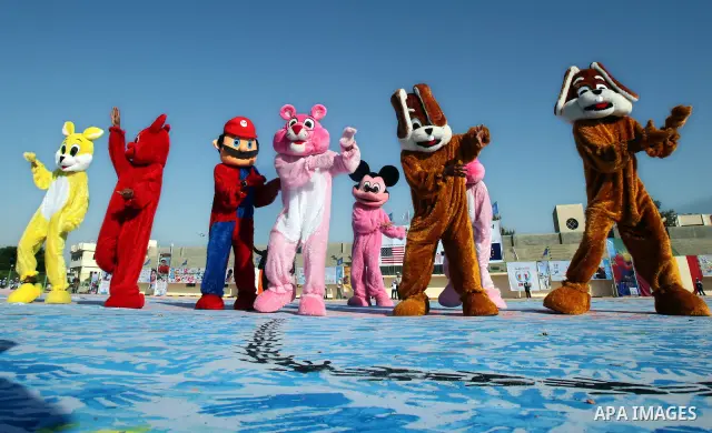 Palestinian children attend an event organised by the the United Nations Relief and Works Agency (UNRWA) in which they attempt to break the Guinness world record for the largest hand-print paint in Khan Yunis, southern G...