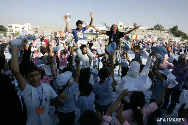 Palestinian children attend an event organised by the the United Nations Relief and Works Agency (UNRWA) in which they attempt to break the Guinness world record for the largest hand-print paint in Khan Yunis, southern G...