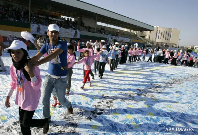 Palestinian children attend an event organised by the the United Nations Relief and Works Agency (UNRWA) in which they attempt to break the Guinness world record for the largest hand-print paint in Khan Yunis, southern G...