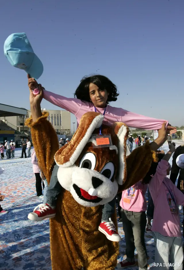 Palestinian children attend an event organised by the the United Nations Relief and Works Agency (UNRWA) in which they attempt to break the Guinness world record for the largest hand-print paint in Khan Yunis, southern G...
