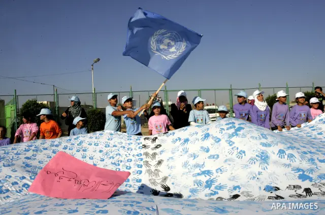 Palestinian children attend an event organised by the the United Nations Relief and Works Agency (UNRWA) in which they attempt to break the Guinness world record for the largest hand-print paint in Khan Yunis, southern G...
