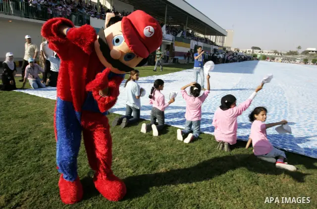 Palestinian children attend an event organised by the the United Nations Relief and Works Agency (UNRWA) in which they attempt to break the Guinness world record for the largest hand-print paint in Khan Yunis, southern G...