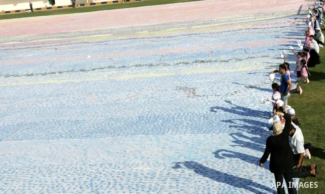 Palestinian children attend an event organised by the the United Nations Relief and Works Agency (UNRWA) in which they attempt to break the Guinness world record for the largest hand-print paint in Khan Yunis, southern G...
