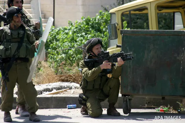 Israeli soldiers take position during a demonstration by Palestinian, Israeli, and foreign protesters in the West Bank village of Beit Omar, near Hebron Friday, July 22, 2011. The demonstration concerned a recent video r...