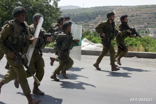 Israeli soldiers take position during a demonstration by Palestinian, Israeli, and foreign protesters in the West Bank village of Beit Omar, near Hebron Friday, July 22, 2011. The demonstration concerned a recent video r...