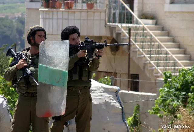 Israeli soldiers take position during a demonstration by Palestinian, Israeli, and foreign protesters in the West Bank village of Beit Omar, near Hebron Friday, July 22, 2011. The demonstration concerned a recent video r...