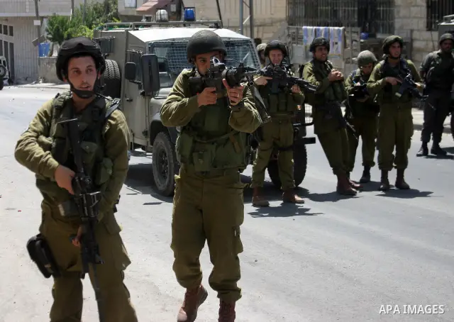 Israeli soldiers take position during a demonstration by Palestinian, Israeli, and foreign protesters in the West Bank village of Beit Omar, near Hebron Friday, July 22, 2011. The demonstration concerned a recent video r...
