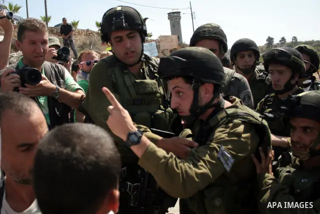 An Israeli soldier scuffles with a protester during a demonstration by Palestinian, Israeli, and foreign protesters in the West Bank village of Beit Omar, near Hebron Friday, July 22, 2011. The demonstration concerned a...