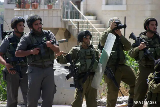 Israeli soldiers take position during a demonstration by Palestinian, Israeli, and foreign protesters in the West Bank village of Beit Omar, near Hebron Friday, July 22, 2011. The demonstration concerned a recent video r...