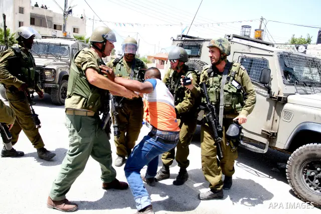 Israeli soldiers detain a protester during clashes with Palestinian protesters from the West Bank village of Nabi Saleh, north of Ramallah, on July 22, 2011 during a weekly Friday protest against Israeli West Bank settle...