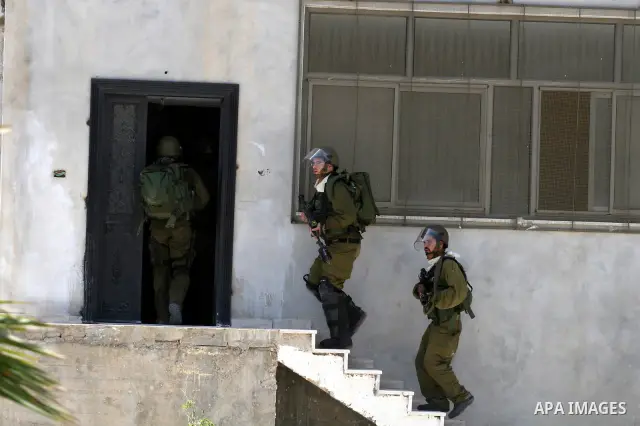 Israeli soldiers take positions during clashes with Palestinian protesters from the West Bank village of Nabi Saleh, north of Ramallah, on July 22, 2011 during a weekly Friday protest against Israeli West Bank settlement...