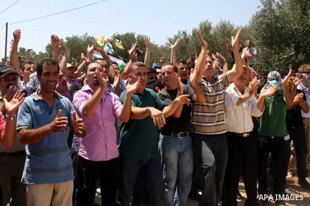 Palestinian protestors take part in a demonstration by against the closure of a road during the second Intifada by Jewish settlers from the nearby settlement of Kadumim , on July 22, 2011 in the West Bank village of Kfar...