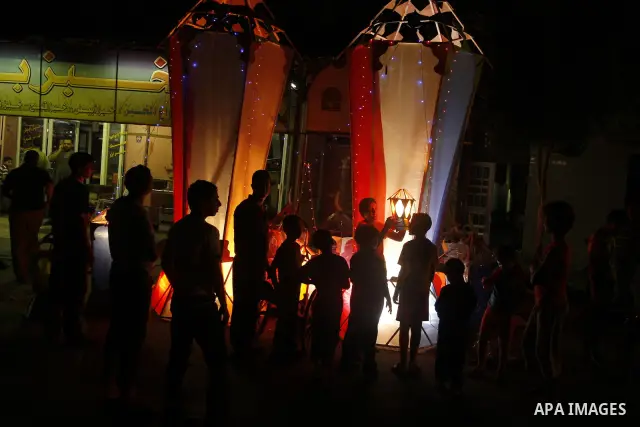 Palestinian children gather around a giant paper lantern, traditionally used as decoration during the Muslim holy month of Ramadan, in Gaza City on July 23, 2011. Photo by Mahmud Nassar