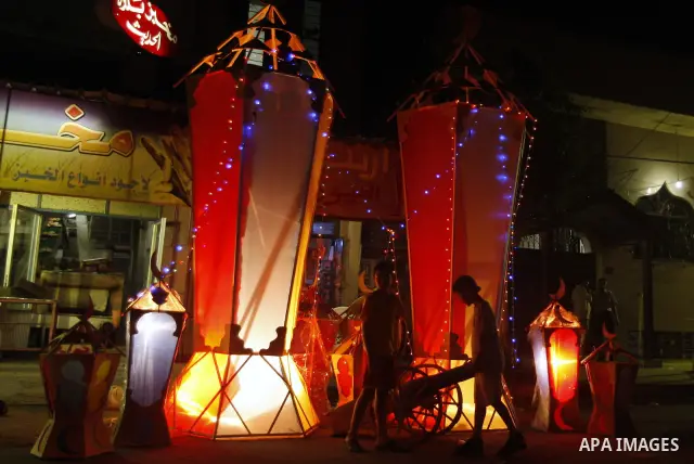Palestinian children gather around a giant paper lantern, traditionally used as decoration during the Muslim holy month of Ramadan, in Gaza City on July 23, 2011. Photo by Mahmud Nassar