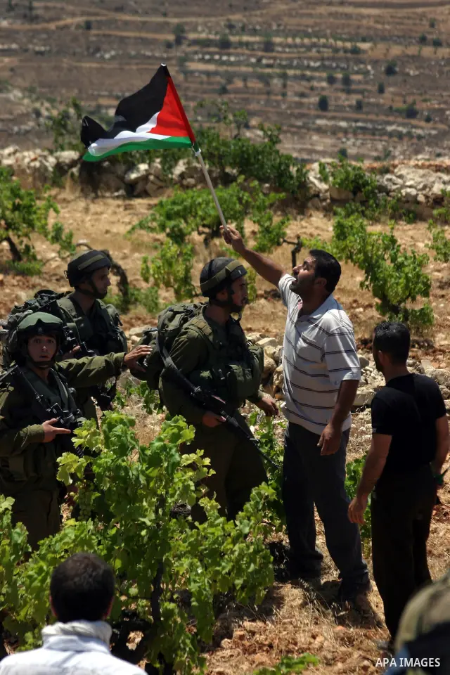 A protester argues with Israeli soldiers during a demonstration against Israel's controversial separation barrier in the West Bank village of Beit Omar, near Hebron, 23 July 2011. Israel says the network of steel and con...