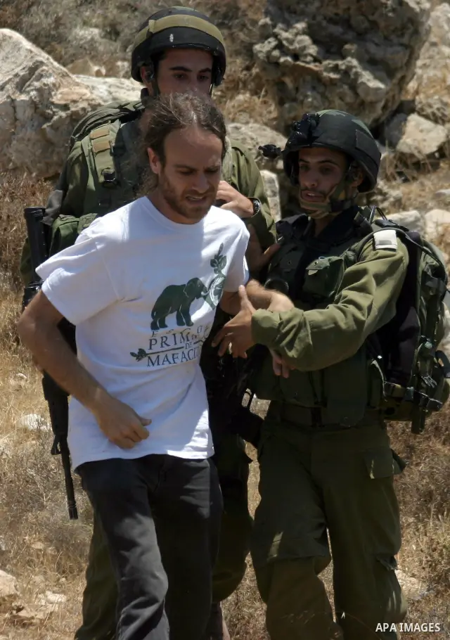 An Israeli soldier detains a protester during a demonstration against Israel's controversial separation barrier in the West Bank village of Beit Omar, near Hebron, 23 July 2011. Israel says the network of steel and concr...