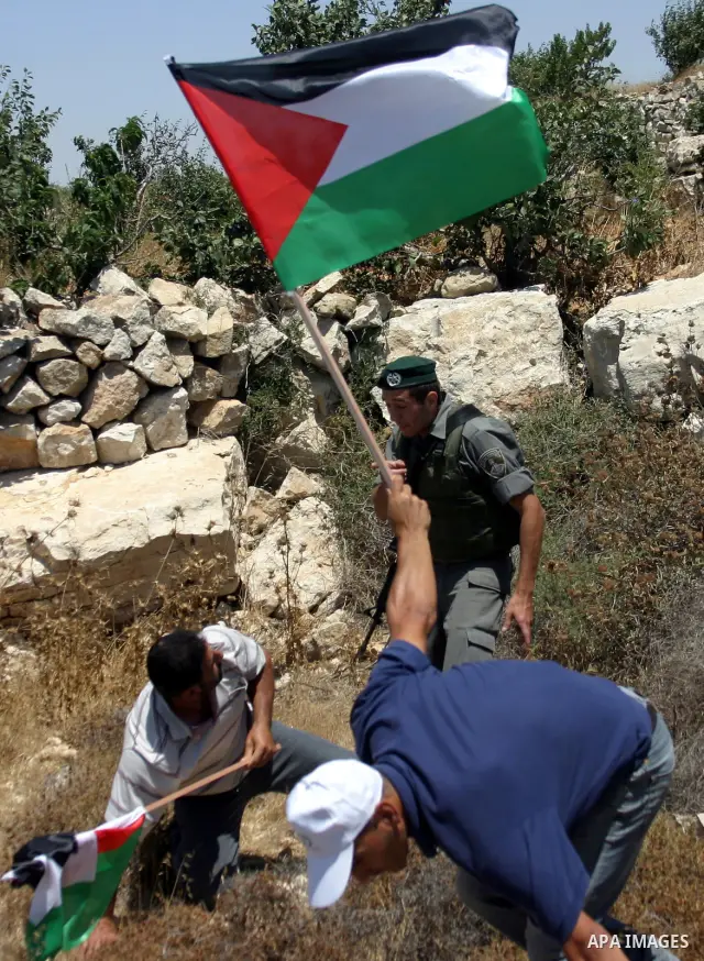A protester argues with Israeli soldiers during a demonstration against Israel's controversial separation barrier in the West Bank village of Beit Omar, near Hebron, 23 July 2011. Israel says the network of steel and con...