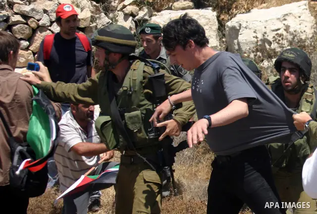 An Israeli soldier detains a protester during a demonstration against Israel's controversial separation barrier in the West Bank village of Beit Omar, near Hebron, 23 July 2011. Israel says the network of steel and concr...