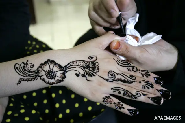 A Palestinian woman applies henna on the hand of a girl during a summer camp organised by the Ministry of Youth and Sports in Rafah, southern Gaza Strip, on July 23, 2011. Photo by Abed Rahim Khatib