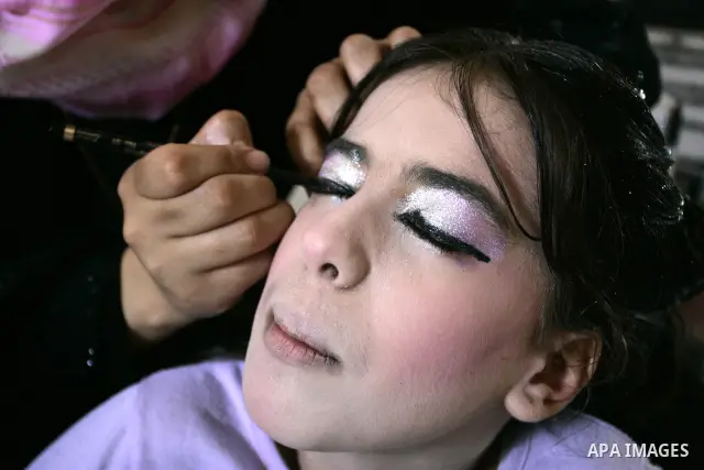 A Palestinian woman applies makeup on the face of a girl during a summer camp organised by the Ministry of Youth and Sports in Rafah, southern Gaza Strip, on July 23, 2011. Photo by Abed Rahim Khatib