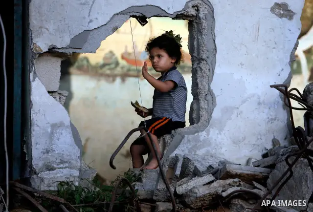A Palestinian child plays inside her family destroyed house in Jabaliya refugee camp, in the northern Gaza Strip on 23 July 2011 house was destroyed during the Israeli assault on Gaza in late 2008 to early 2009, and beca...