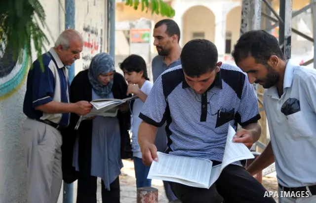 Palestinian relatives of secondary school students read a local newspaper to find their results in Gaza city on July 24,2011. The Ministry of Education in Gaza Strip and the West Bank announced the results together. Phot...