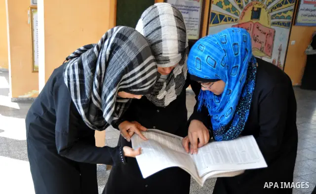 Palestinian secondary school students read a local newspaper to find their results in Gaza city on July 24,2011. The Ministry of Education in Gaza Strip and the West Bank announced the results together. Photo by Majdi Fa...