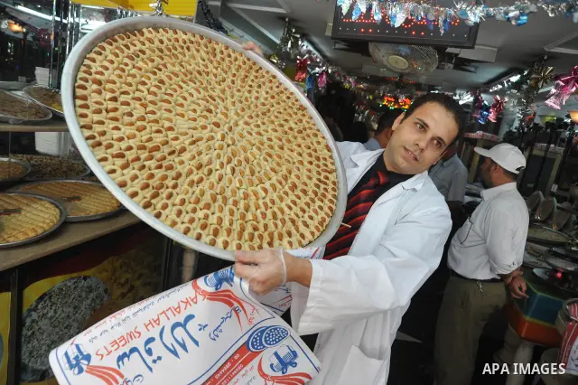 A Palestinian vendor distributes sweets after the results of high school exams, or "Tawjihe", in in Gaza city on July 24, 2011. Photo by Majdi Fathi