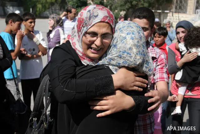 Palestinian relatives Hug their secondary school students after find their results in the West Bank city of Hebron on July 24, 2011.Photo by Najeh Hashlamoun