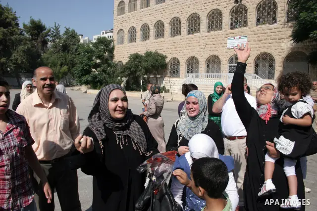 Palestinian relatives Hug their secondary school students after find their results in the West Bank city of Hebron on July 24, 2011.Photo by Najeh Hashlamoun