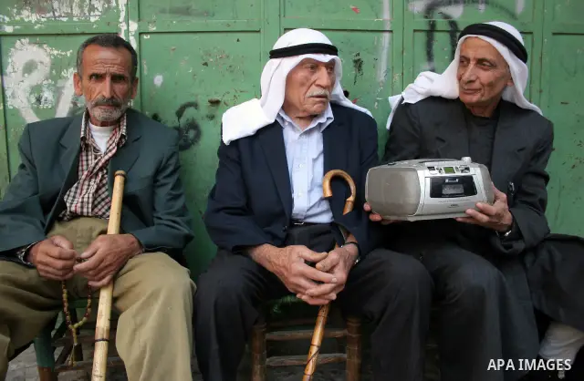 Palestinians listen to the radio waiting the results of secondary school students in the West Bank city of Hebron on July 24, 2011. Photo by Najeh Hashlamoun